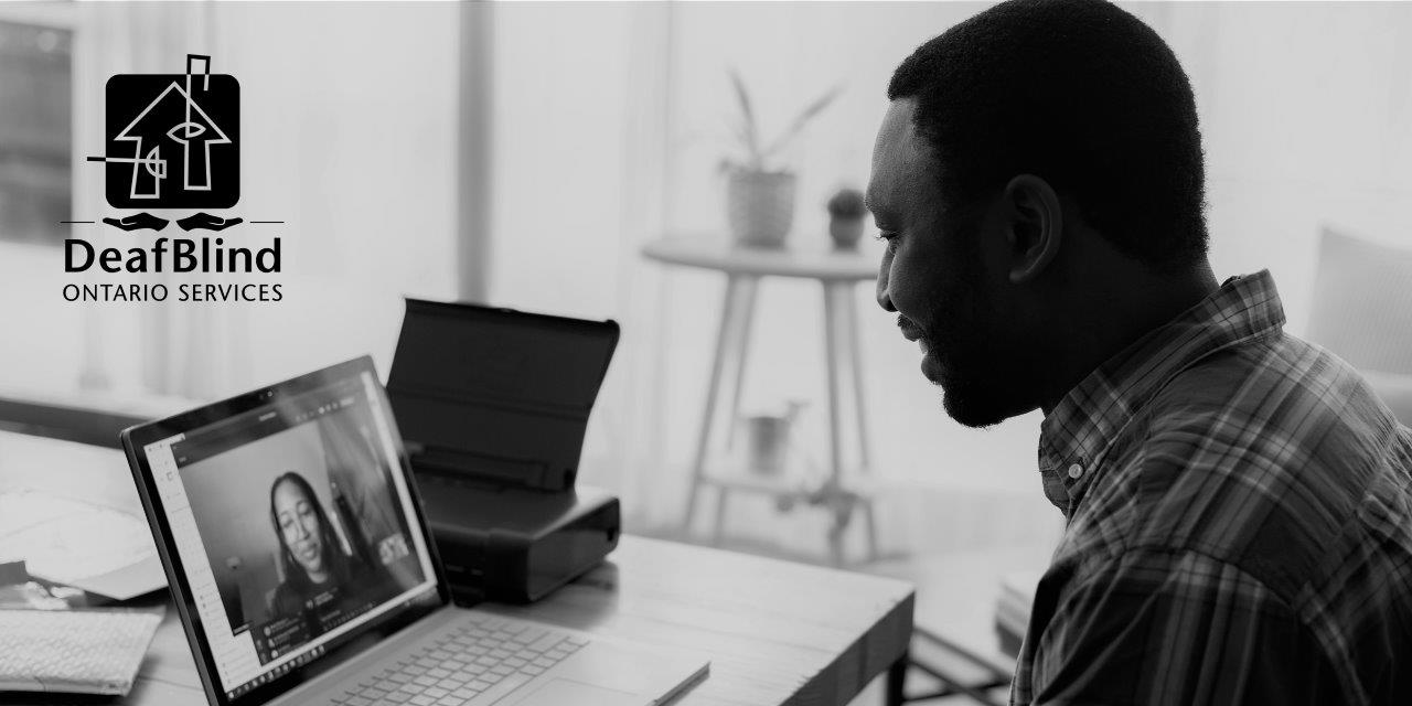 Man smiling at woman on screen of open laptop