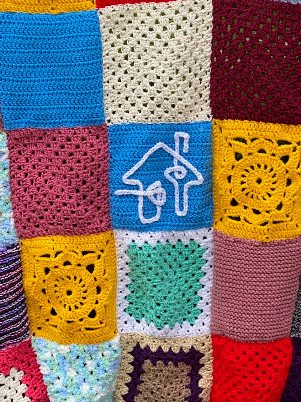 Colourful knit squares joined together to cover a community object.