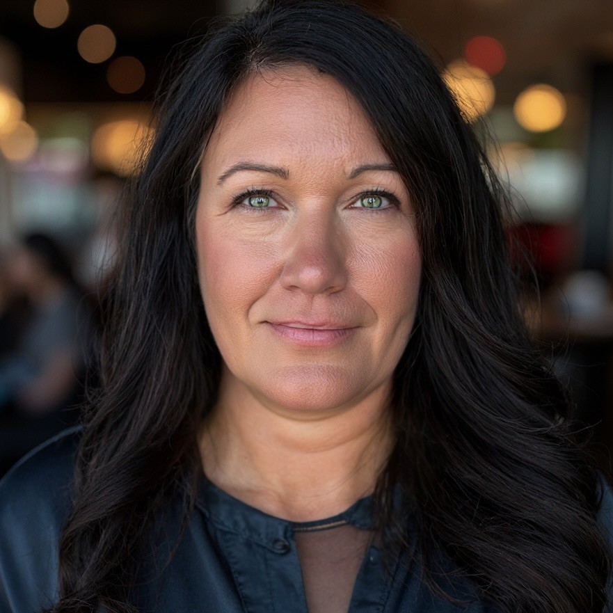 Loran Upton Image of woman with brown hair, light gray jacket, black shirt and pearl necklace